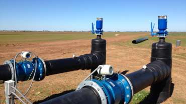 Two black Magflow meters in an open field